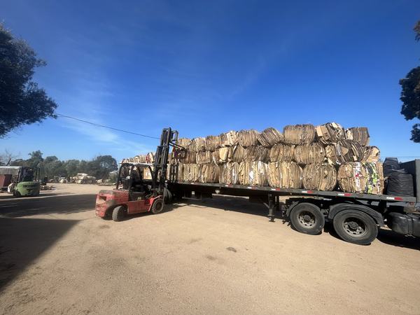 Fardos de cartón cargados en un camión con autoelevador en la planta de Biotrade para enviar a reciclaje